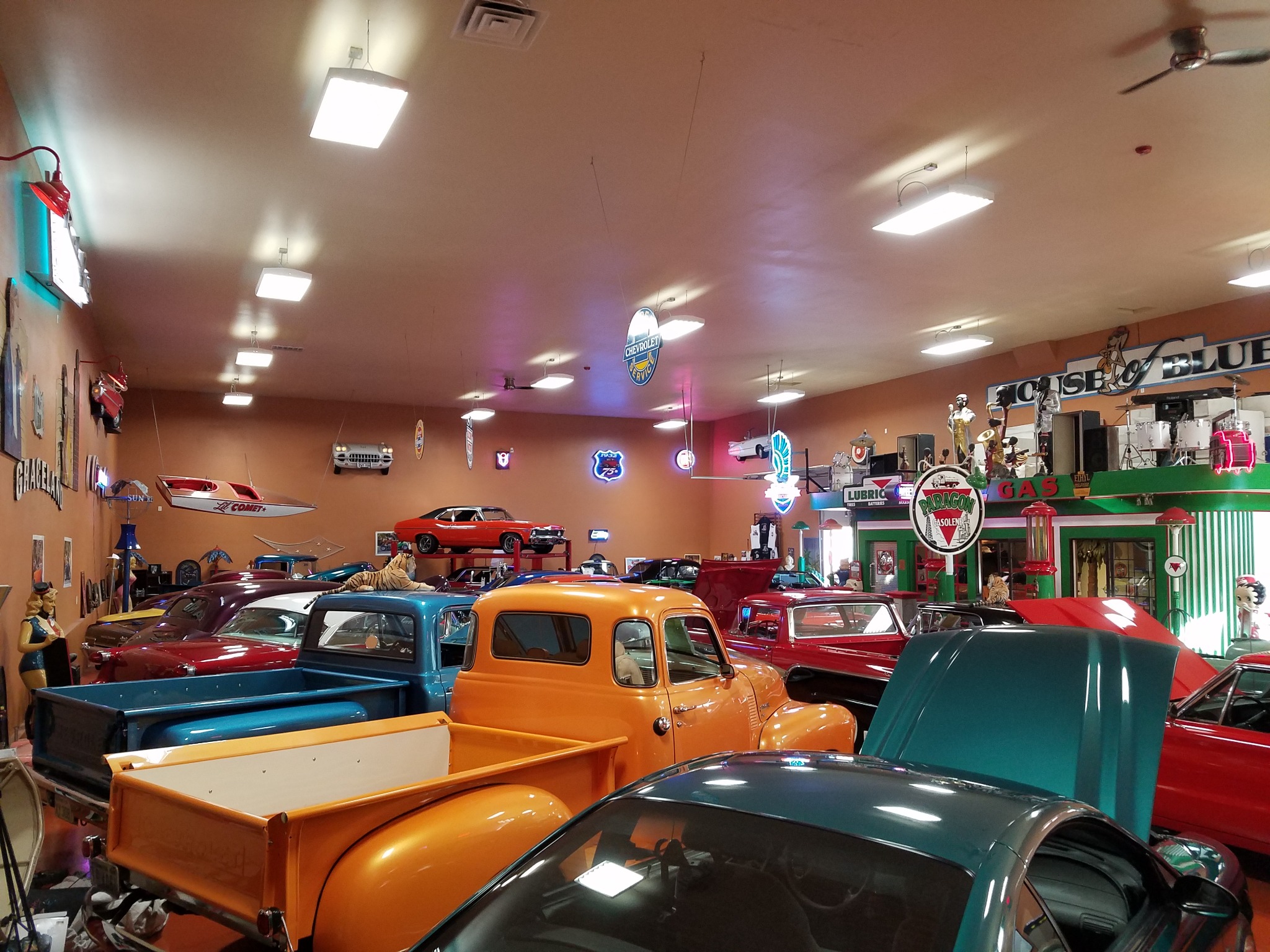 Orange and blue classic trucks among collector cars in the former showroom
